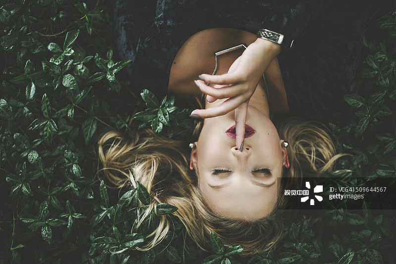 女人躺在綠色植物的戶外圖片素材