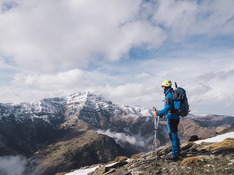 年長的高山攀登者在冬季觀看山頂的美景圖片素材