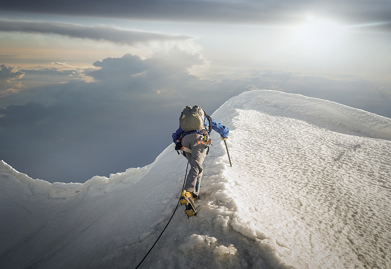 攀登者在積雪的山脊上圖片素材