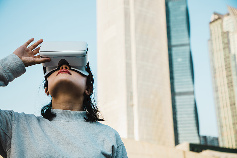 女人使用虛擬現實耳機在城市景觀圖片素材