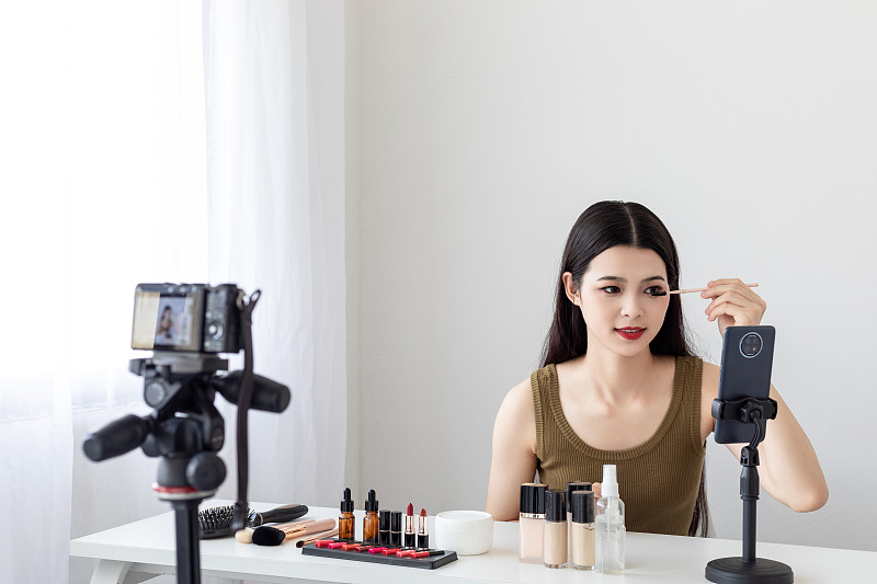 室内一名漂亮的亚洲美女在做美妆直播图片下载