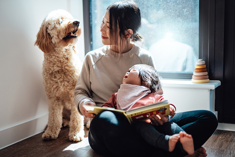 亚洲妈妈和她的宝贝女儿和她的狗一起读书图片下载