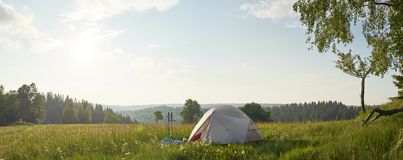 帳篷搭在茂盛的草地和綠色的環境中攝影圖片