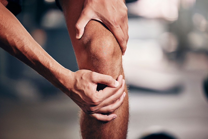 健身，運動和男子與膝蓋疼痛在健身房，近距離的手抱膝蓋受傷后。運動、健康與損傷男性運動員在鍛煉、訓練和運動后腿部關節疼痛圖片下載