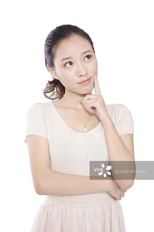 Young woman standing,looking up,thinking图片素材