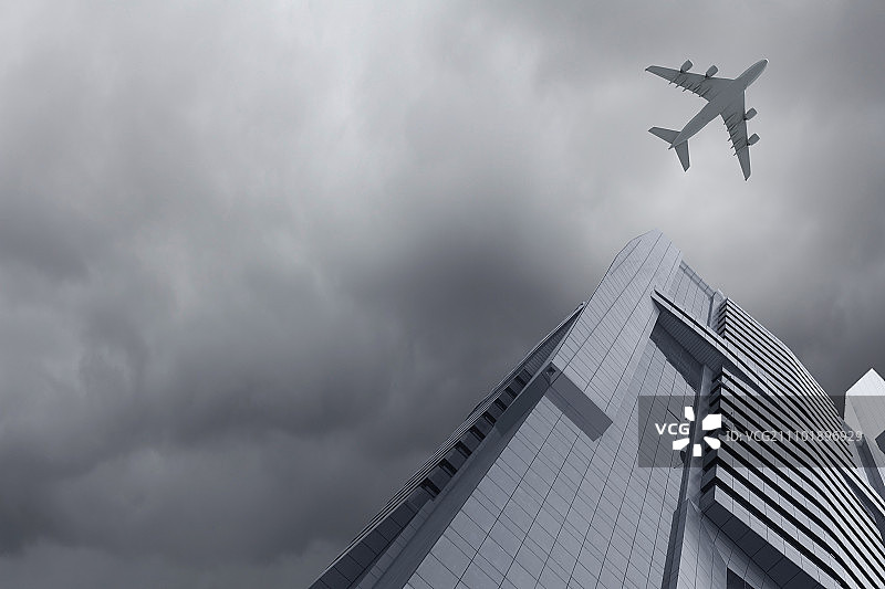 飞机飞行。飞机在摩天大楼上方飞行的底部视图图片素材