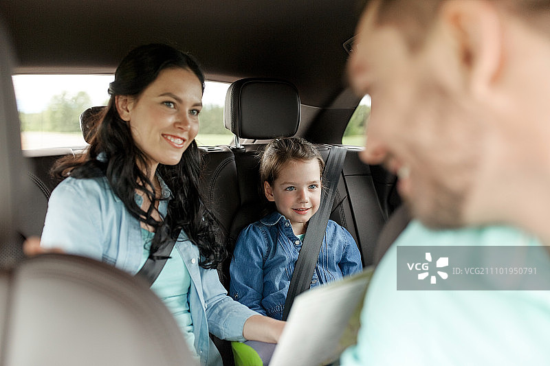 家庭，交通，公路旅行和人的概念-幸福的女人和小女儿与地图驾驶在汽车图片素材