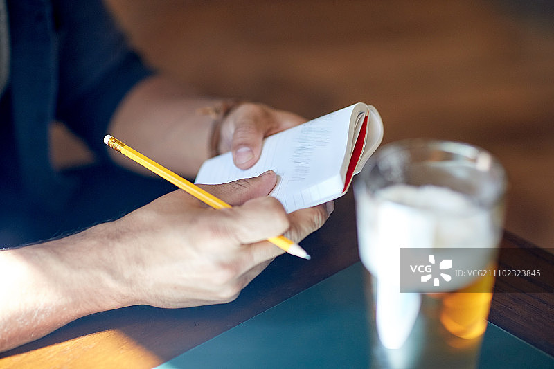 人，灵感，自由职业者和休闲概念-近距离的男人与啤酒写作笔记本在酒吧或酒吧图片素材