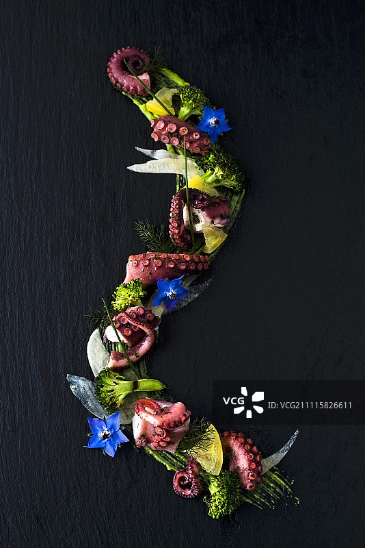 开胃菜:腌过的章鱼、柠檬和烤花椰菜，配以琉璃苣花图片素材