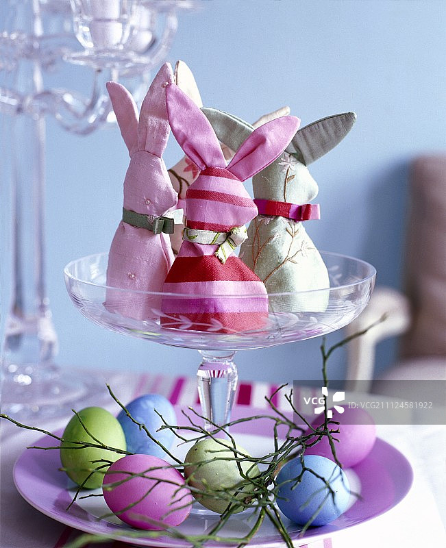 在大玻璃上自己缝兔子和在盘子上的复活节彩蛋图片素材
