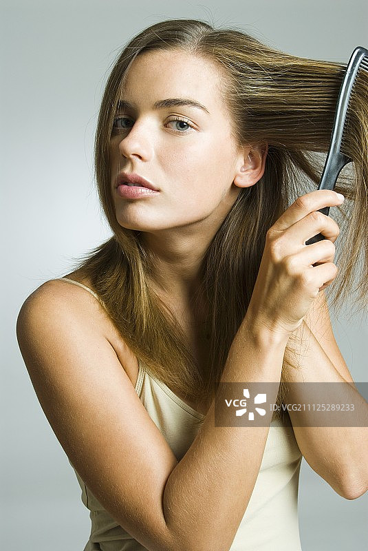 一个深色金发的女人在梳头图片素材