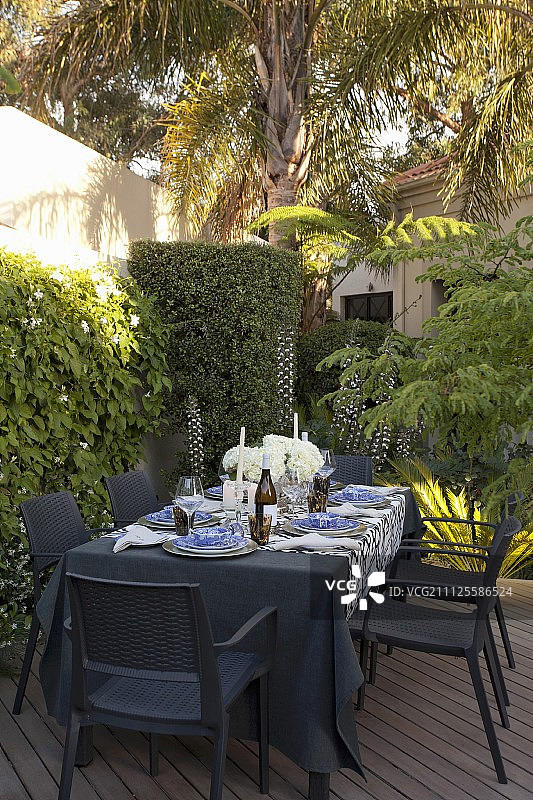设置桌子，黑色花园家具和爬坡墙庭院露台图片素材