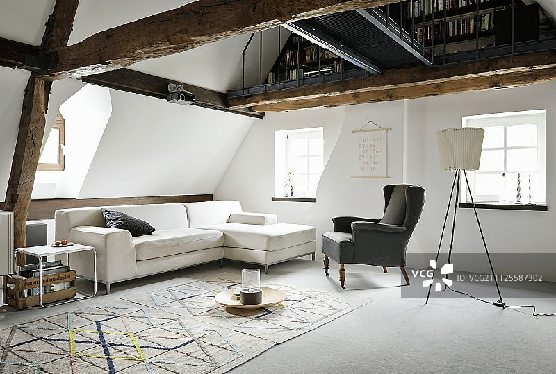沙发，靠背椅，古典的边桌和几何地毯下面的开放式画廊图片素材