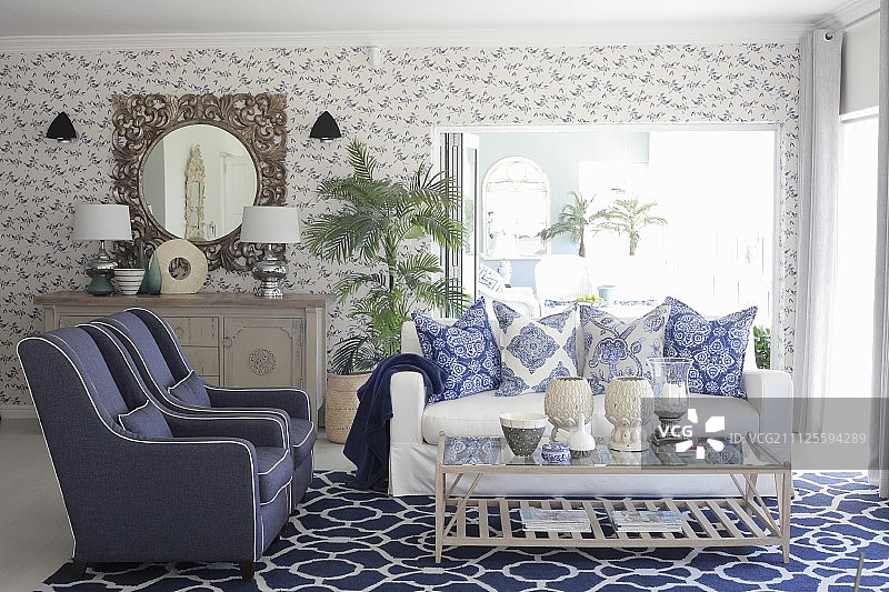 蓝白相间的客厅，墙纸、靠垫和地毯上有混合图案图片素材