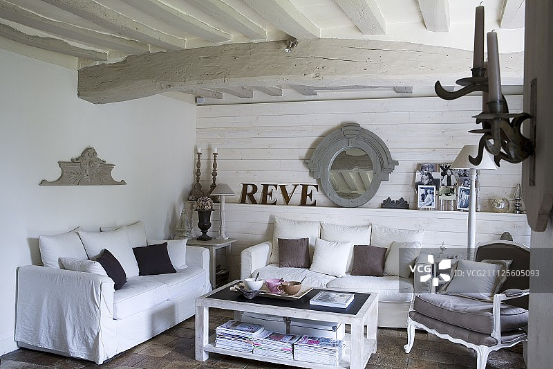 白色沙发，散垫和古董扶手椅在客厅，白色木梁天花板图片素材