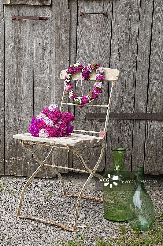 乡村谷仓门前的老式折叠椅上放着花束和心形愤怒的甜威廉姆斯图片素材