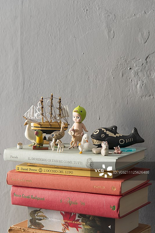靠着灰色的墙壁，书架上放着复古玩具和迷你雕像图片素材
