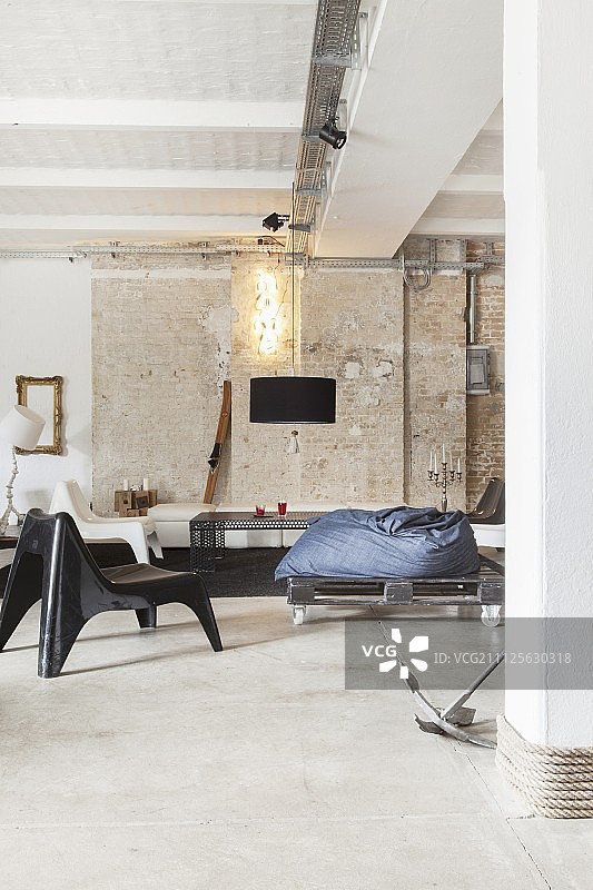 休息室在工业风格的阁楼公寓，砖墙和混凝土地板图片素材