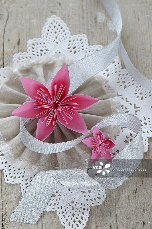 折叠纸花花边和织物玫瑰结图片素材