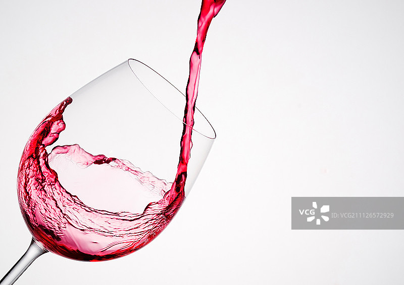 以对角线的形式倒入玻璃杯中的葡萄酒图片素材