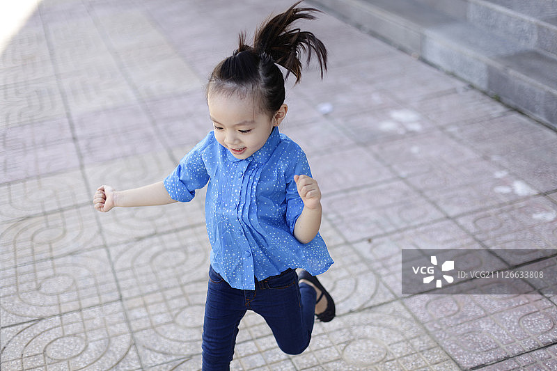可爱可爱甜美的亚洲中国小女孩与微笑的脸在路上图片素材