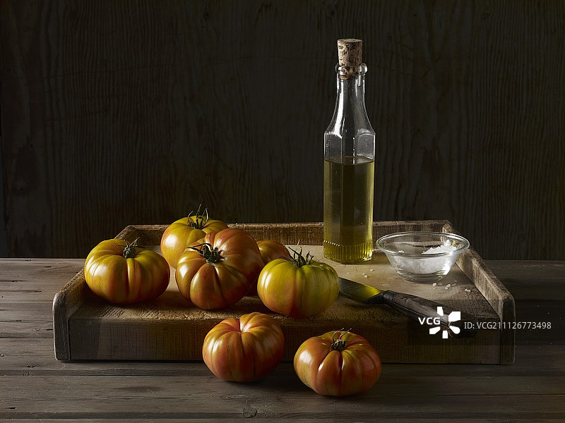 用橄榄油，盐和一把刀在木板上烤番茄图片素材