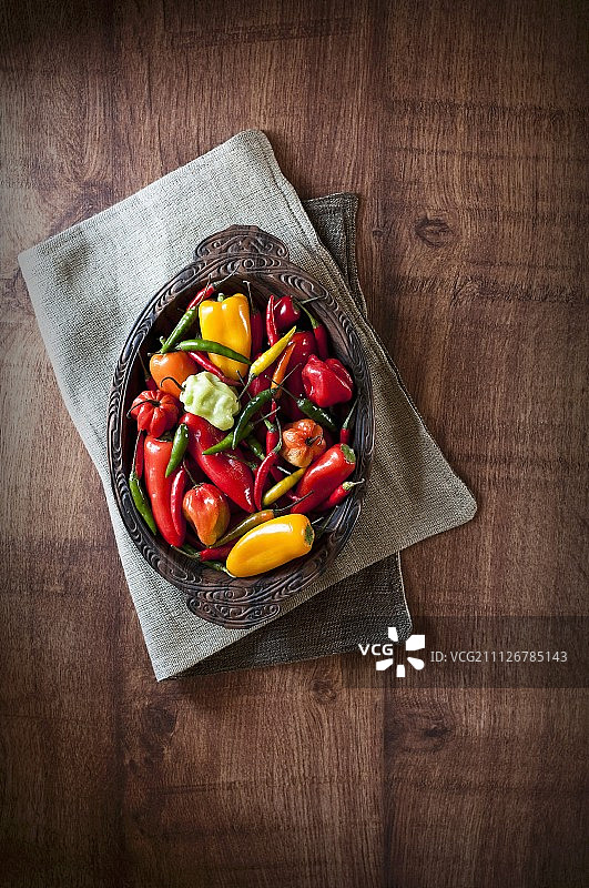 各种新鲜的辣椒放在一个木碗里(从上面看)图片素材
