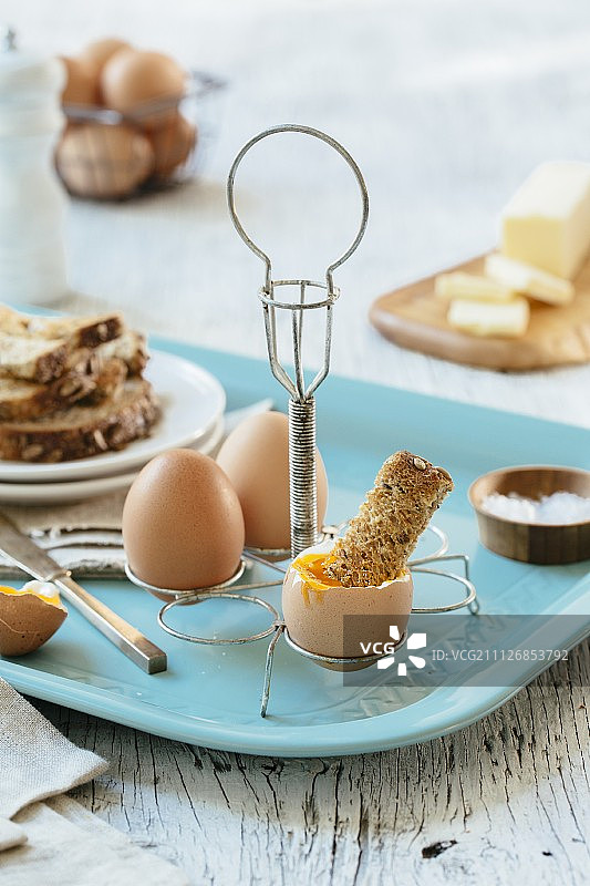 半熟鸡蛋和吐司放在蛋架上图片素材