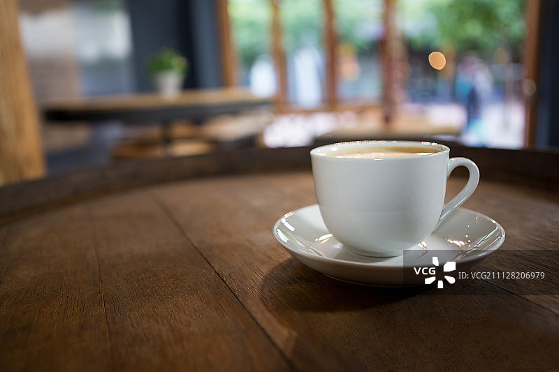 咖啡馆的木桌上放着一杯咖啡图片素材