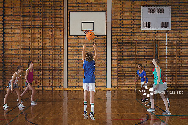 下定决心的高中生在球场上打篮球图片素材