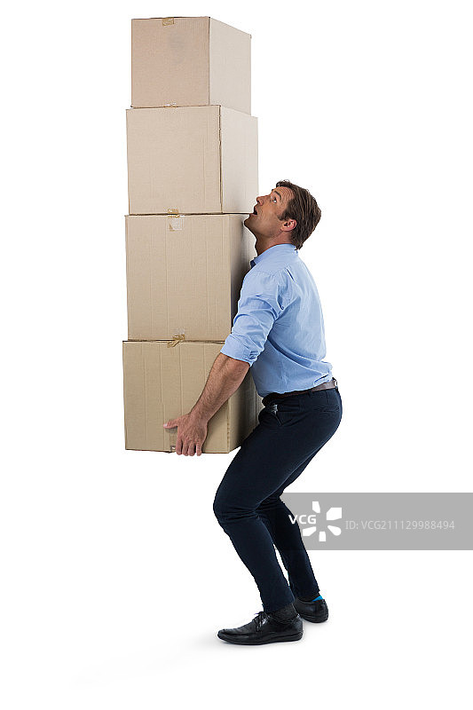 在白色背景下，一名男性高管拿着一堆纸板箱图片素材