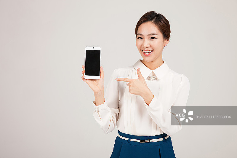 一个年轻的韩国女人拿着手机图片素材