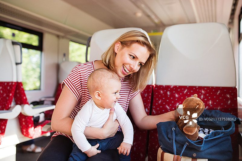 年轻的母亲带着婴儿乘火车旅行。图片素材