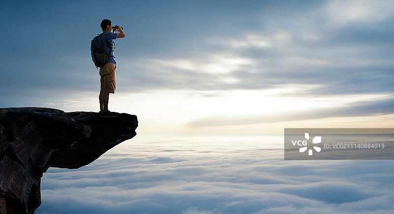 中年男人站在悬崖上远眺图片素材