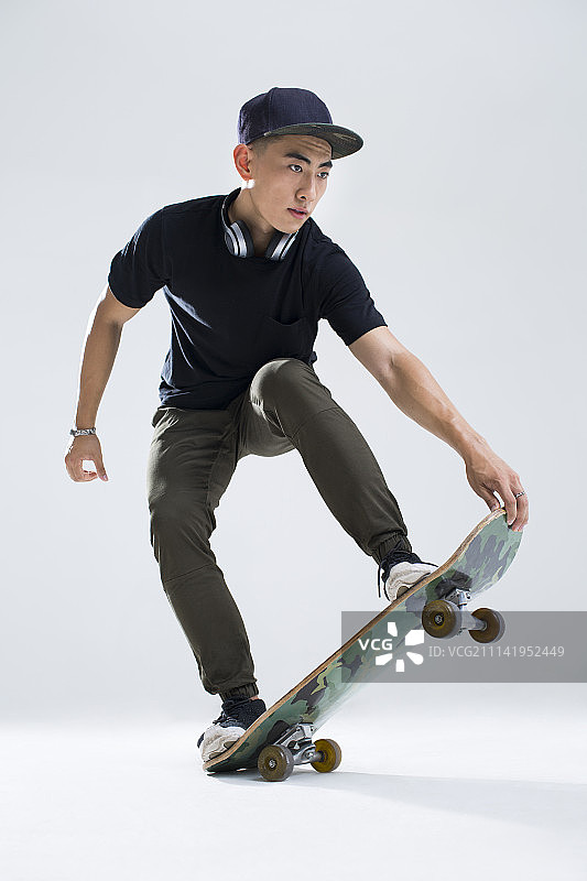 戴耳机的年轻男子在滑滑板图片素材