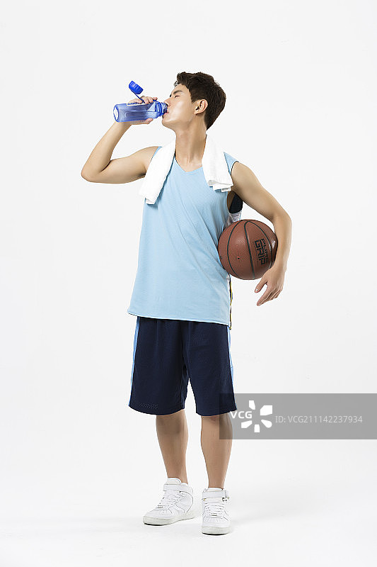 穿着运动服的男人拿着篮球喝水图片素材
