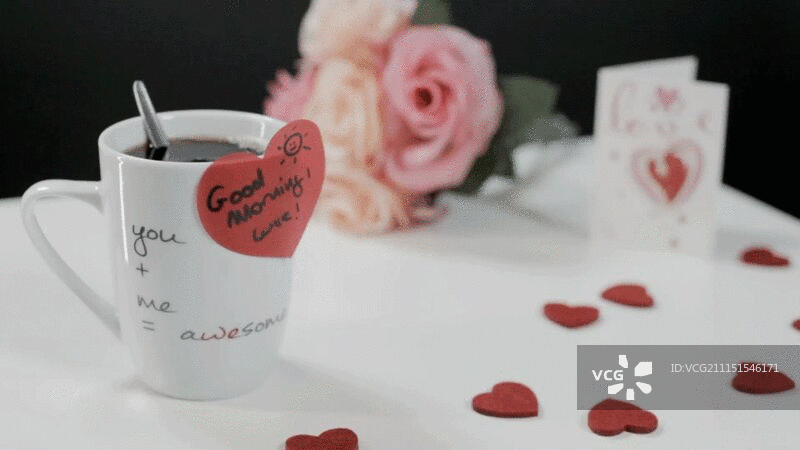 一杯有心形贴纸的咖啡，桌上有心和花图片素材
