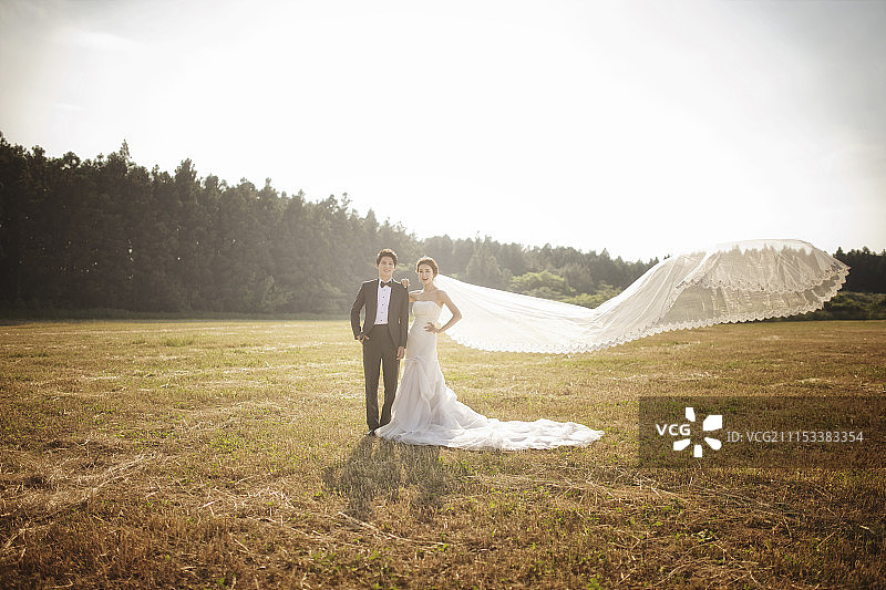 快乐的新娘和新郎在野外摆姿势图片素材
