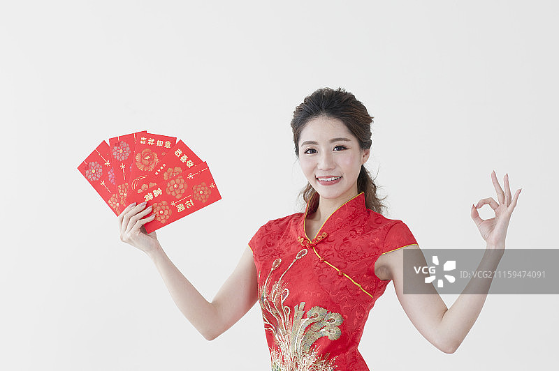 年轻女人穿旗袍拿着红包图片素材