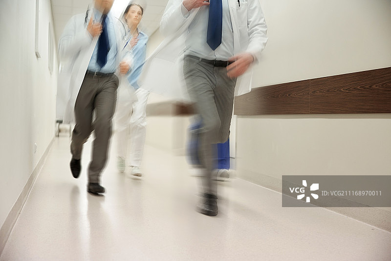 人、保健和医学概念-一组医护人员沿着医院跑(运动模糊效应)。医护人员或医生在医院跑步的特写图片素材