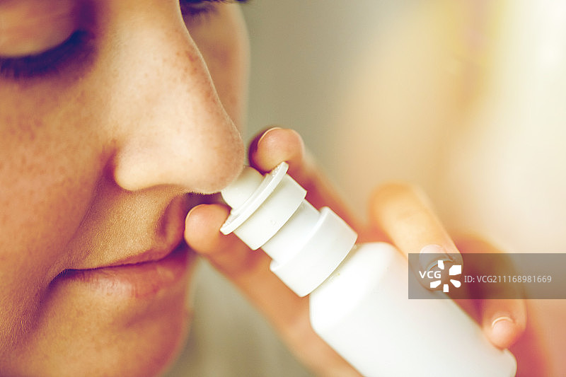 卫生保健，流感，鼻炎，医药和人的概念-关闭患病妇女使用鼻喷雾剂。近距离观察病人使用鼻喷雾剂图片素材