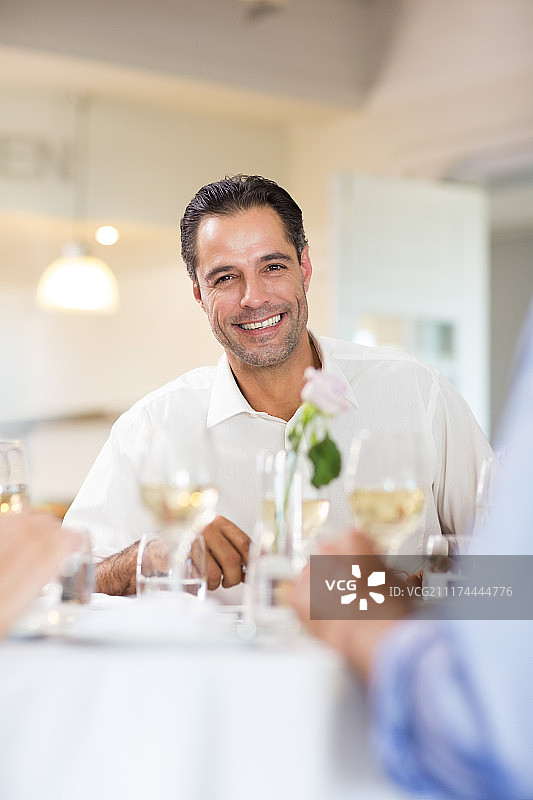 微笑的男人与朋友在餐厅喝酒图片素材