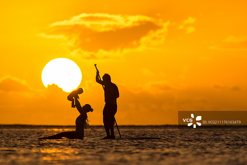 在印度洋岛国毛里求斯，年轻漂亮的父母和孩子一起骑着冲浪板图片素材