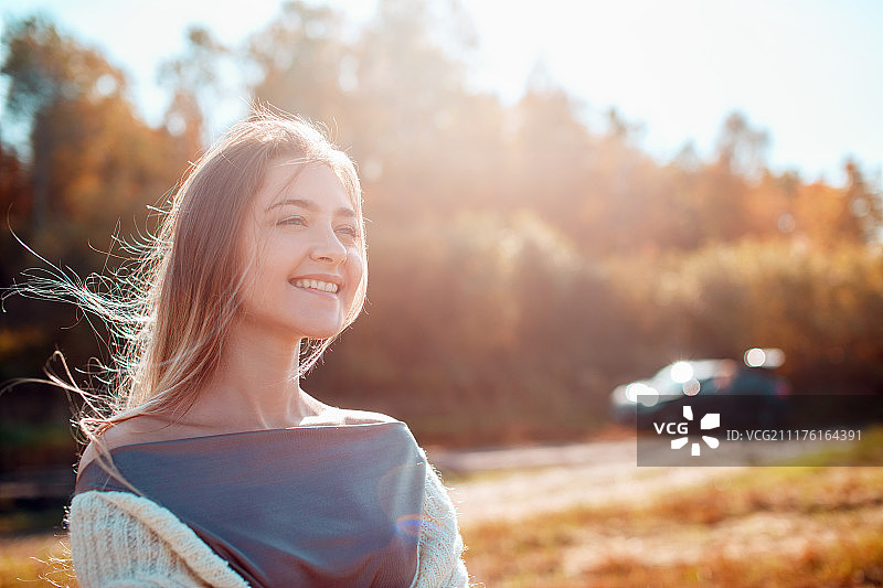 漂亮女孩在镜头前摆姿势，享受阳光明媚的秋日图片素材