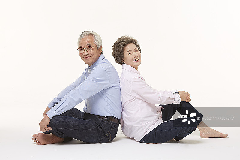 一对老夫妇背靠背坐在地上的照片图片素材