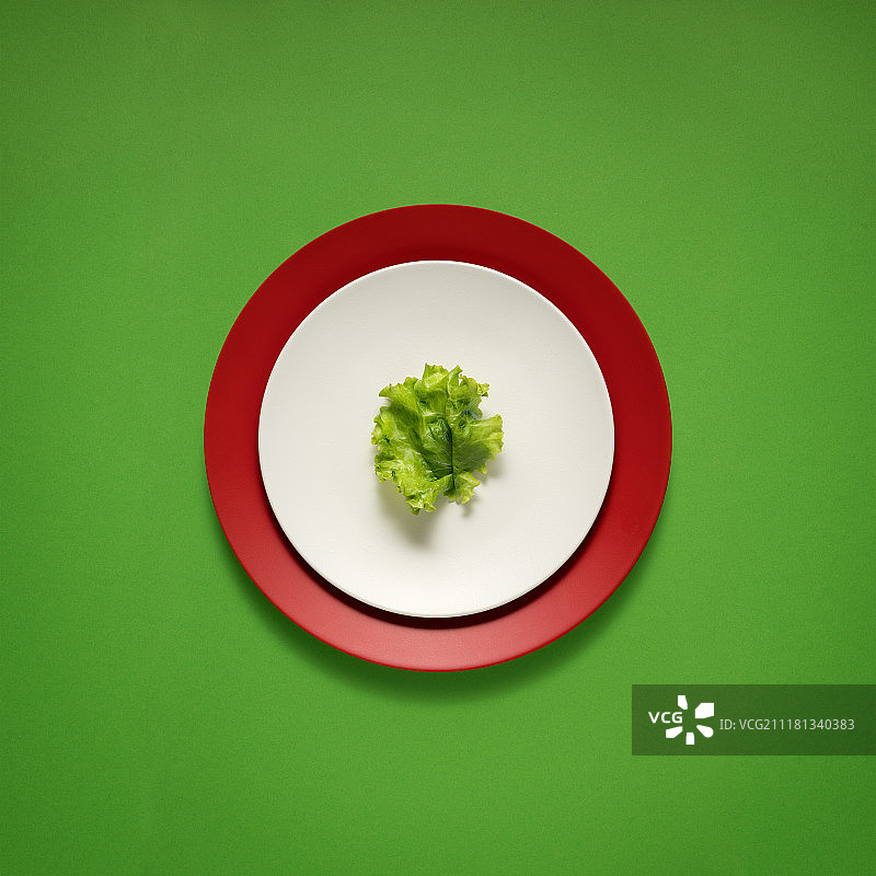 厨房用具的创意照片，在绿色背景上画有食物的盘子。图片素材