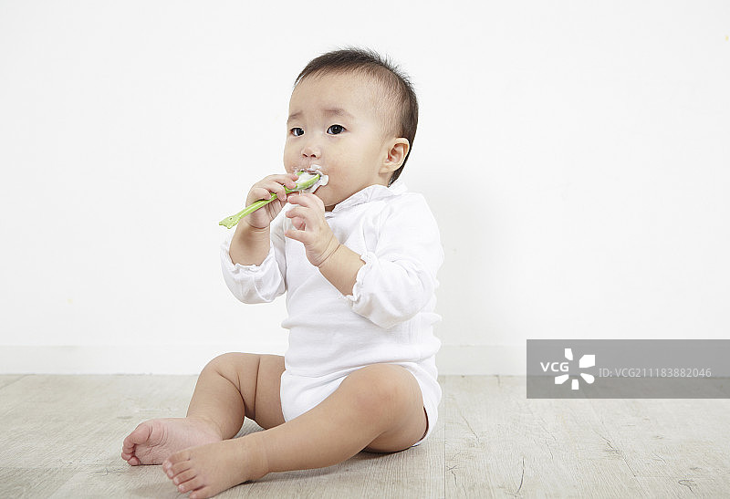 婴儿坐着吃酸奶的照片图片素材