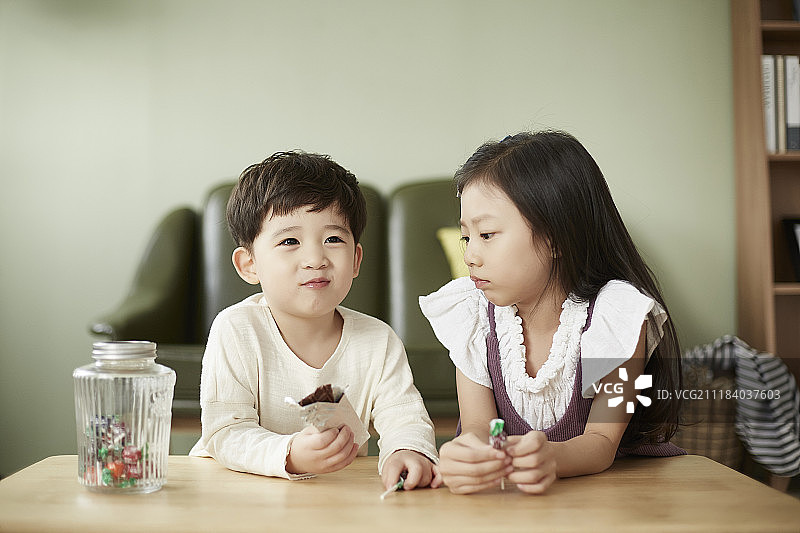 小男孩和小女孩在客厅吃甜点的照片图片素材