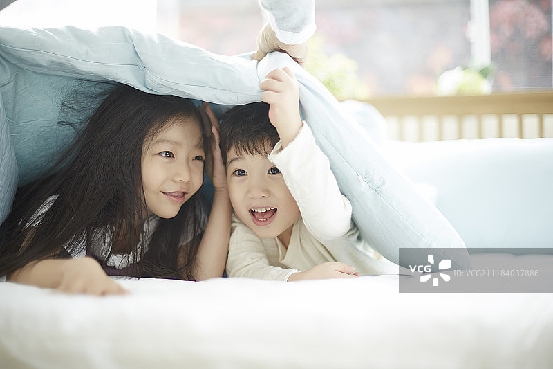 小男孩和小女孩在床上玩耍图片素材