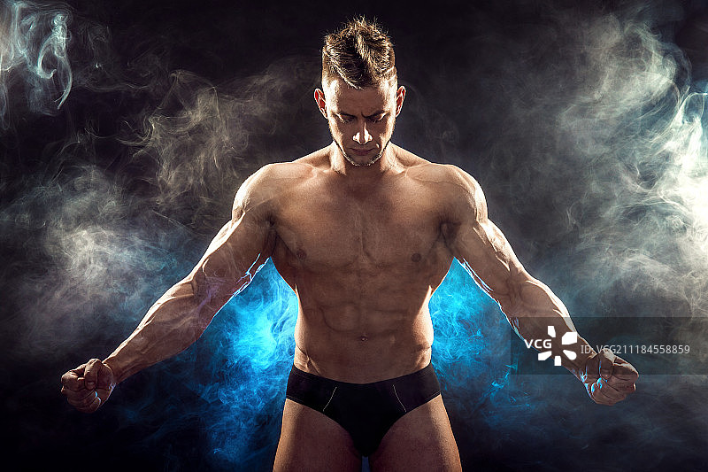 英俊的力量的运动员男子健美运动员健身肌肉的身体在黑烟背景完美图片素材